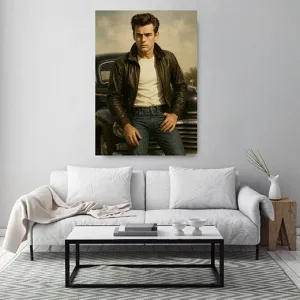 Kunstdruck James Dean – Ein junger Mann in brauner Lederjacke, weißem Shirt und Jeans lehnt lässig an einem dunklen Wagen, der Himmel dahinter ist in weiche Grau- und Olivtöne getaucht