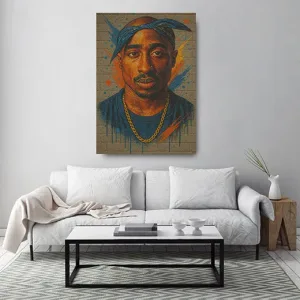 Kunstdruck 2Pac Wall – Das Gesicht mit blauem Bandana und goldener Kette scheint direkt auf eine Ziegelwand gesprüht, dahinter explodieren orange und blaue Farbstrahlen mit feinen Farbläufen